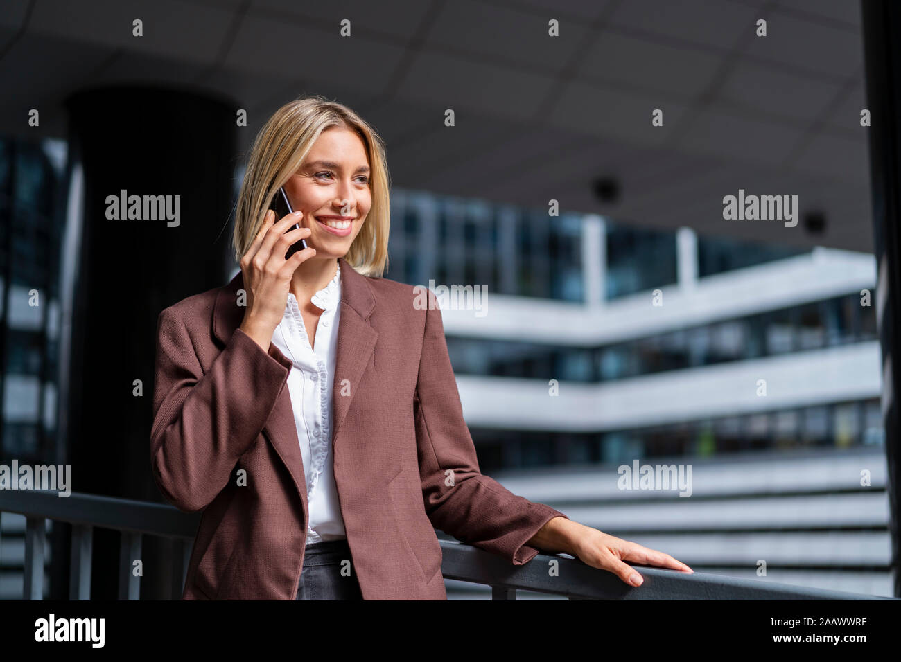 Smiling young businesswoman on the phone in the city Stock Photo