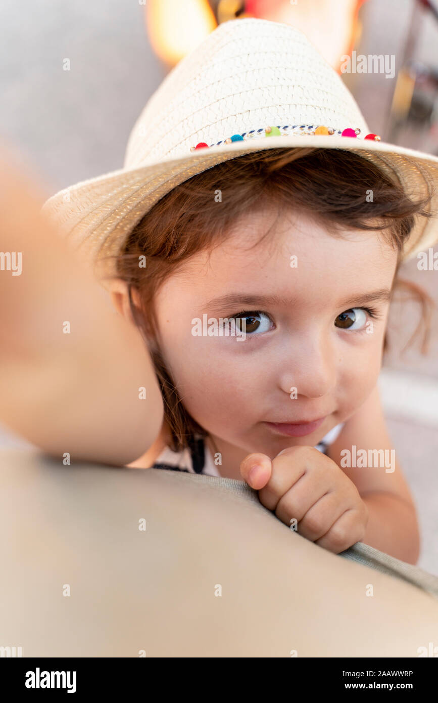 Portrait of little girl with brown hair and eyes wearing straw hat Stock Photo