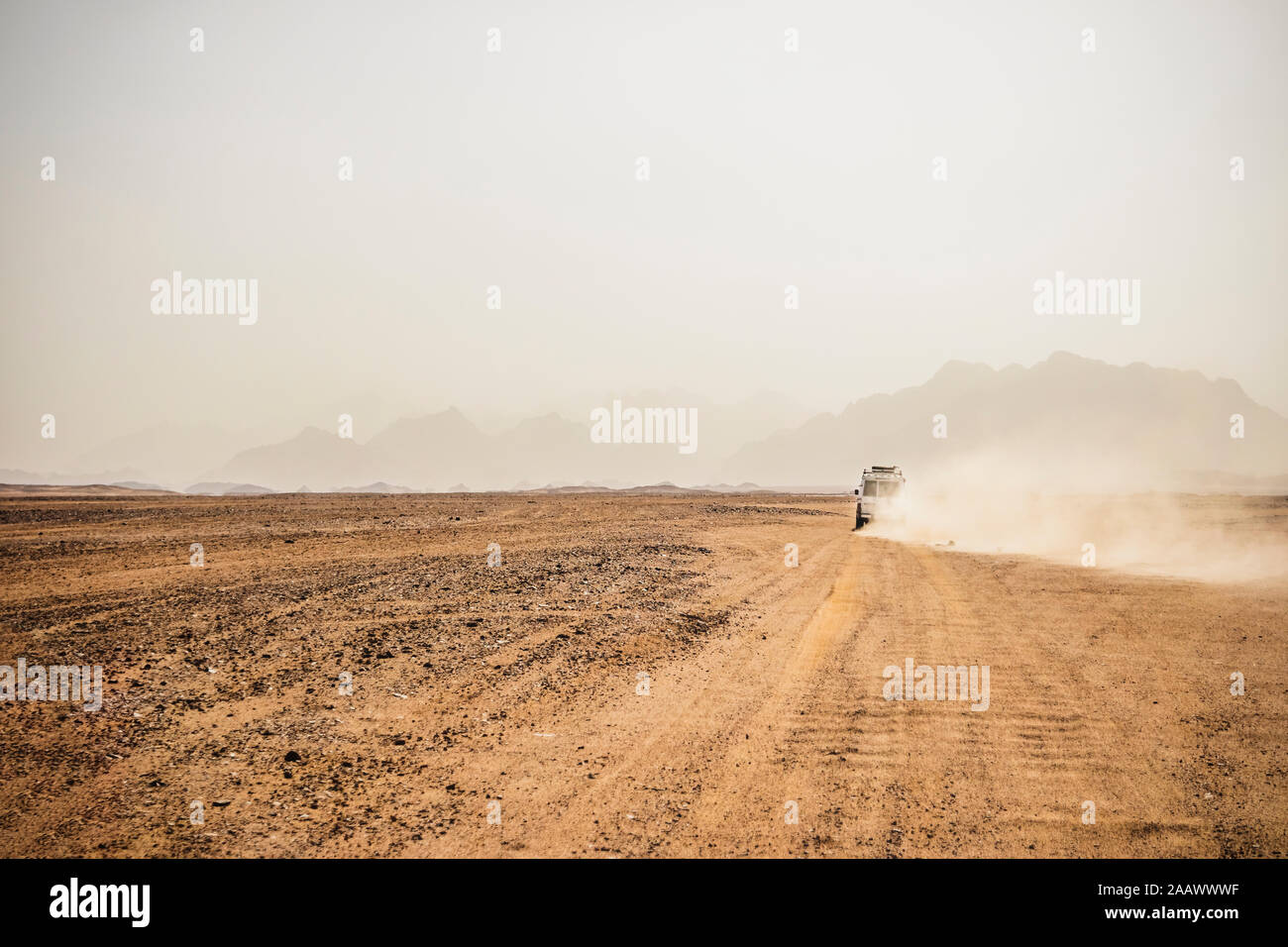 Off-road vehicle moving on arid landscape against clear sky, Suez, Egypt Stock Photo
