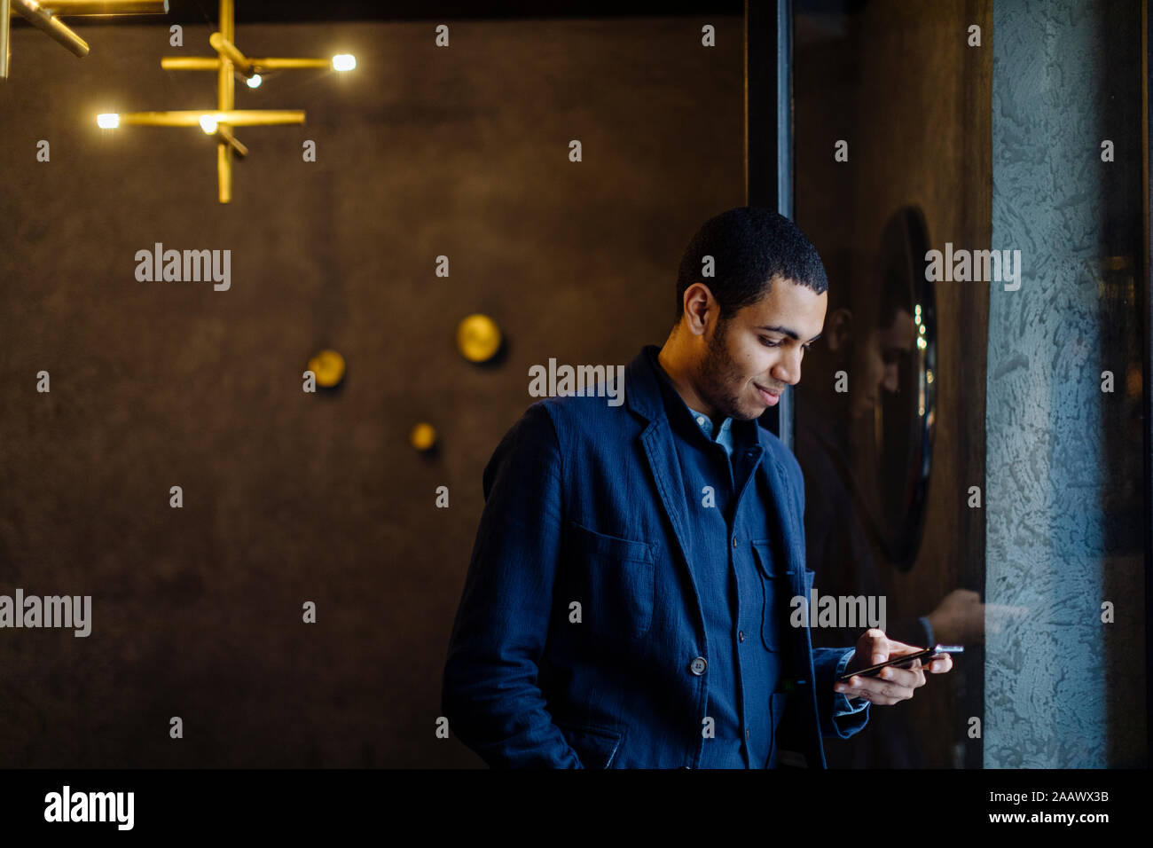Young man in stylish office, using smartphone Stock Photo