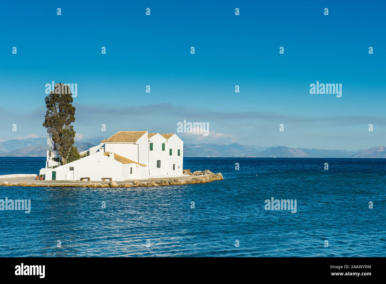 Vlacherna Monastery amidst sea against blue sky at Kanoni, Ionian Islands, Greece Stock Photo
