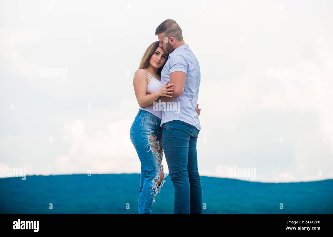 Romantic relations. True love. Family love. Couple in love. Cute relationship. Man and woman cuddle nature background. Supporting her. Together forever. Love story. Just married. Honeymoon concept. Stock Photo