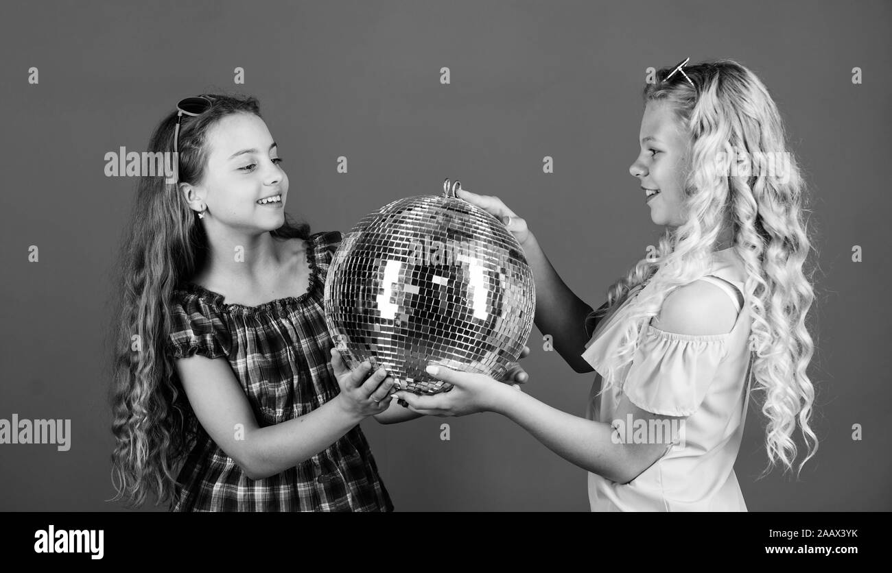 party fun. small girls with disco ball. party goers. happy birthday. holiday celebration. dancing and having fun. small girl spend time together. friendship and sisterhood concept. Stock Photo