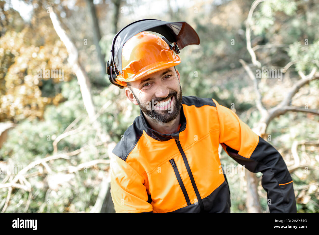 Portrait of a cheerful lumberman in protective workwear resting after the hard work in the forest Stock Photo