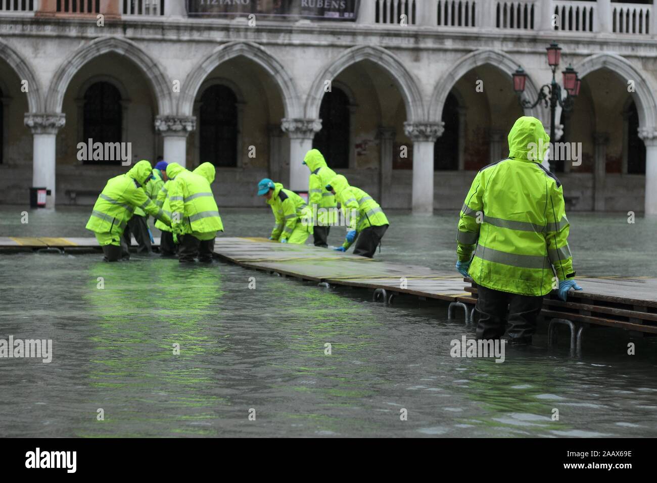People traverse a provisional footpath built over flood waters Stock Photo