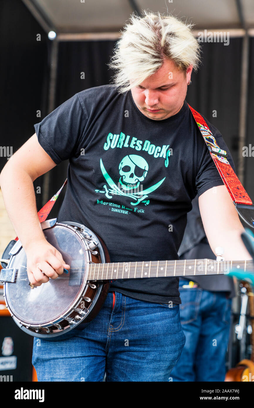 French rock group, Sur Les Docks on stage during the Faversham Hop Festival. Close up of one member of the band playing the electric banjo. Stock Photo