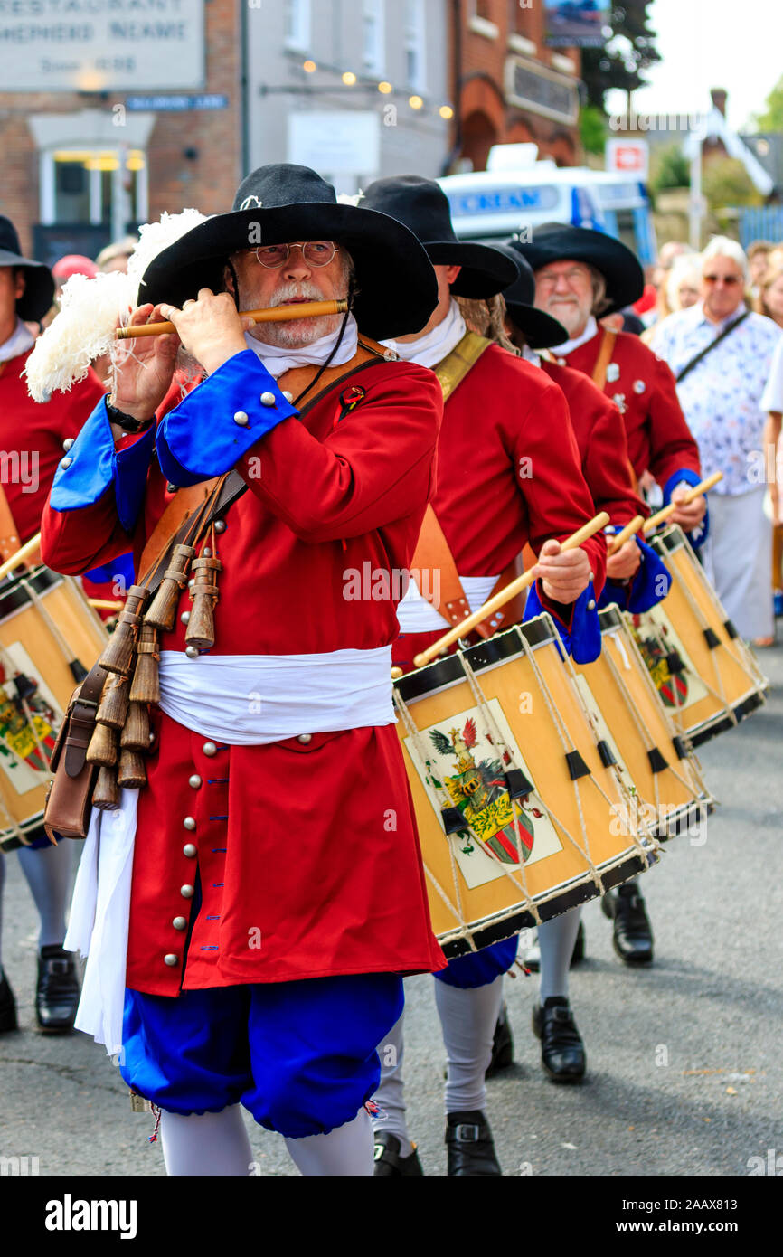 Mature man Flute player from the Dutch Trommelfluit Band marching during a parade at Faversham Hop Festival. Dressed in 17th century orange uniforms. Stock Photo