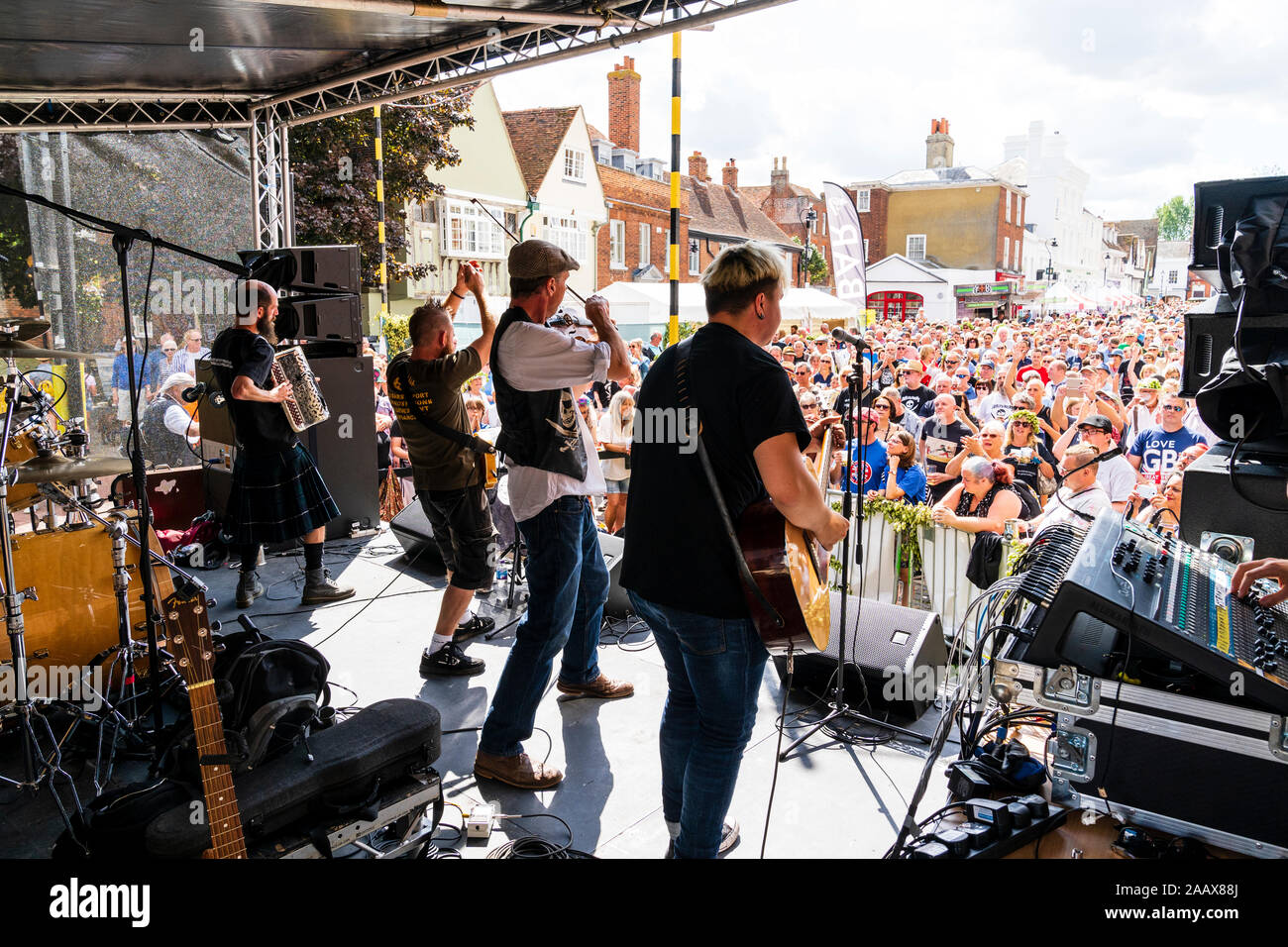 Faversham Hop Festival. Back of stage view of the French rock band 'Sur Les Docks' playing a concert in front of a packed crowd on a summertime day. Stock Photo