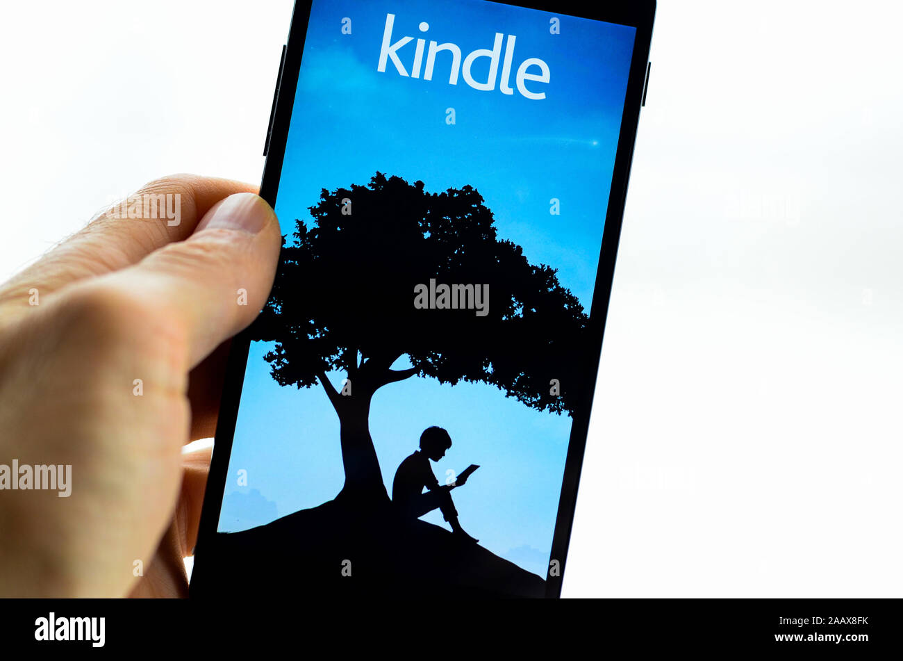 A smartphone with the Kindle app on it. Stock Photo