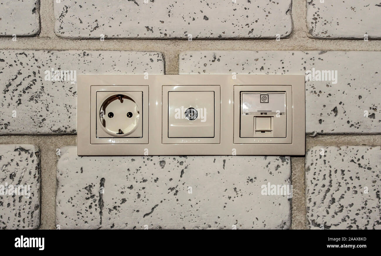 A block of built-in network, television and Internet sockets in a brick wall Stock Photo