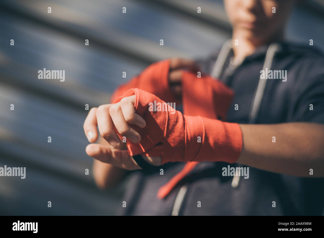 Close up view of young male hands with boxing bands. Boy prepares for a
