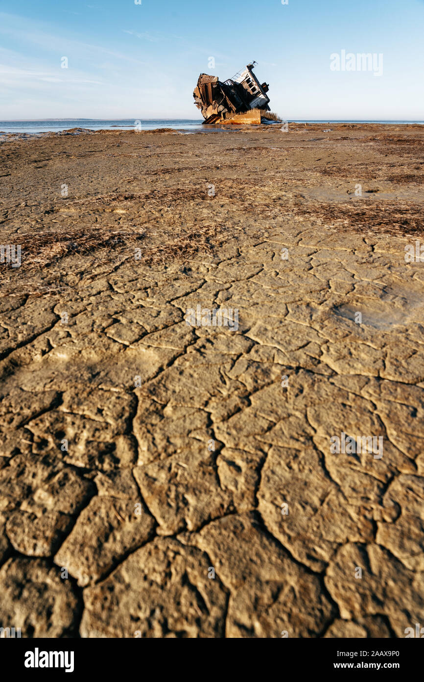 Ship remains on shore of Aral sea or Aral lake with takir, Kazakhstan Stock Photo