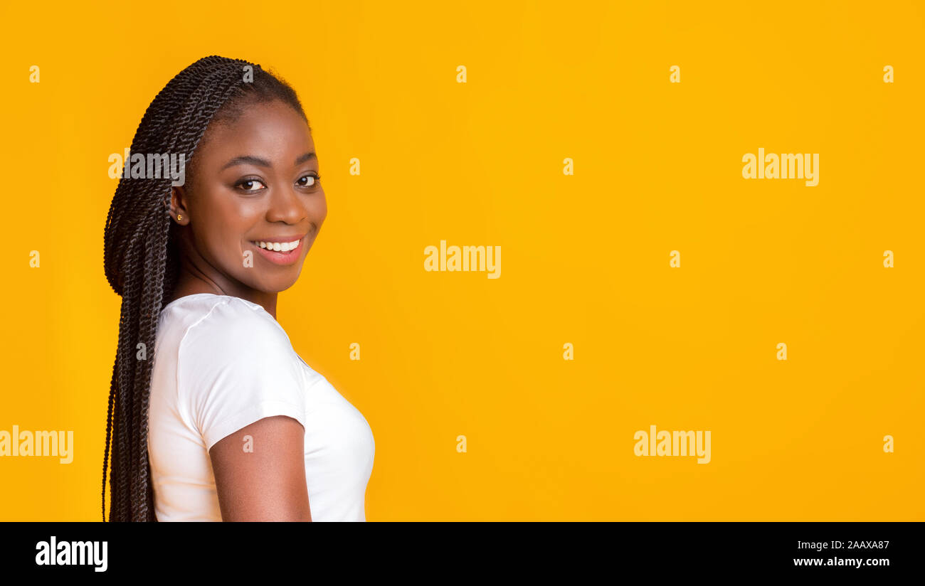 Smiling black girl looking at camera over shoulder Stock Photo