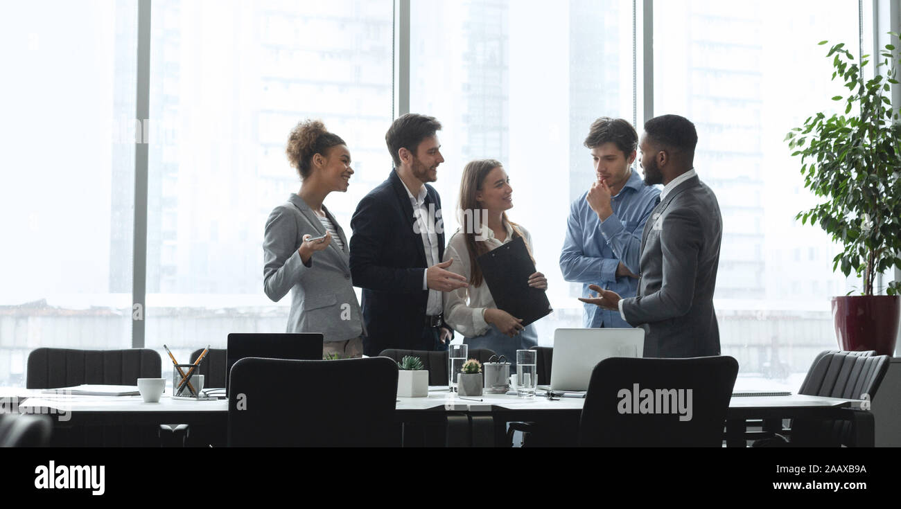 Diverse management team talking in conference room Stock Photo