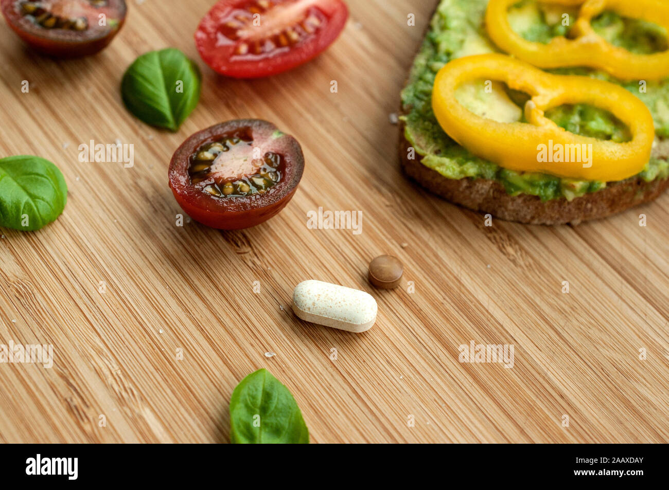 Supplements as part of a natural and balanced diet. Pills and food served together. Future of nutrition. Stock Photo