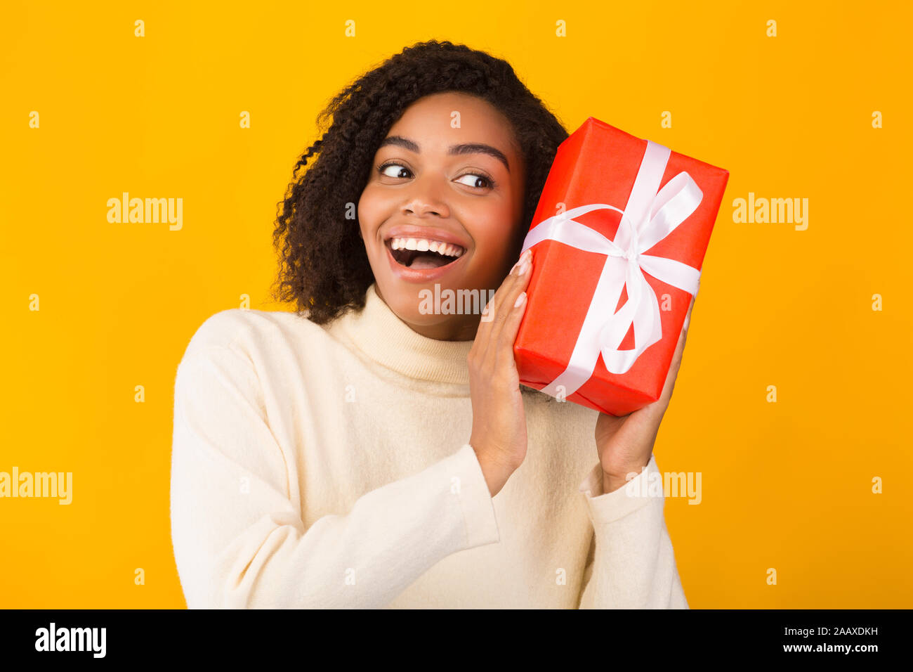 Excited black girl holding new year gift Stock Photo