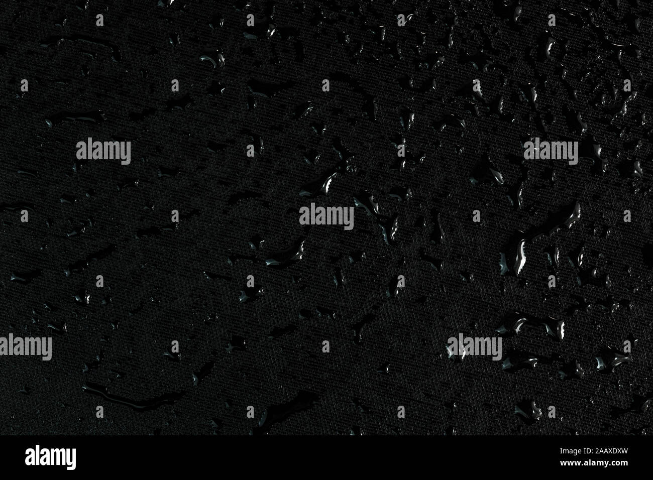 black flat rubber surface with water drops macro background. Stock Photo