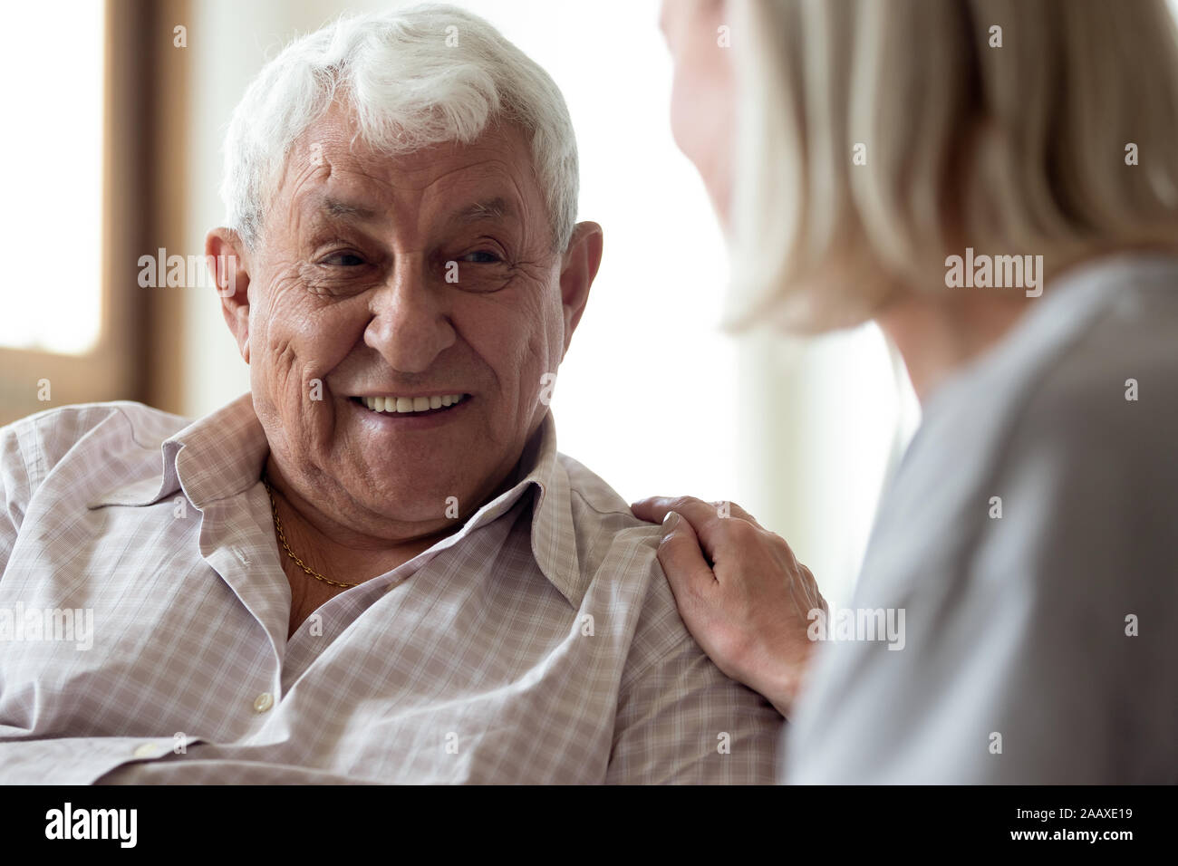 Smiling elder male patient communicating with nurse. Stock Photo