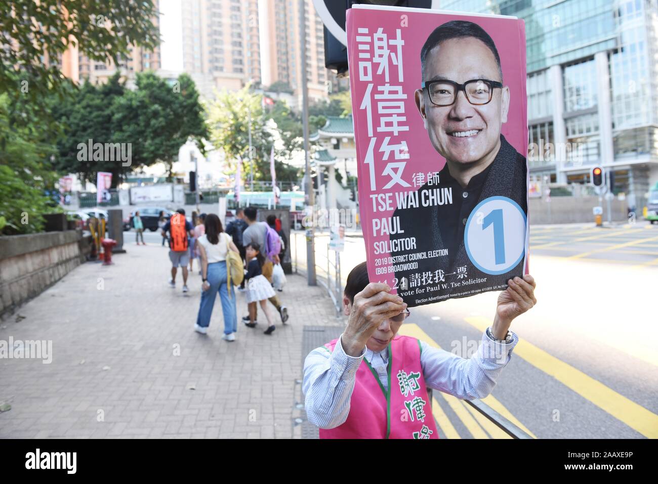 A volunteer campaigns on a street for  pro-establishment lawmaker Paul Tse Wai Chun candidate who seeks reelection ahead of District Council Elections. Hong Kong held its district council election under a rare atmosphere of calm and peace after weeks of intense clashes at numerous universities between anti-government protesters and police which continue into its sixth month of demonstrations. Stock Photo