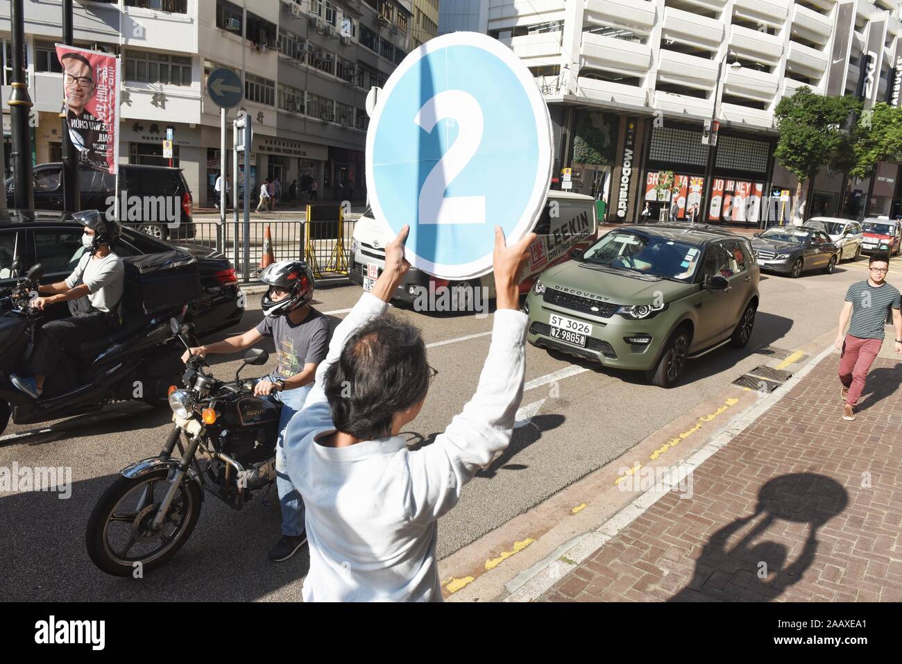 A volunteer campaigns on a street ahead of District Council Elections. Hong Kong held its district council election under a rare atmosphere of calm and peace after weeks of intense clashes at numerous universities between anti-government protesters and police which continue into its sixth month of demonstrations. Stock Photo