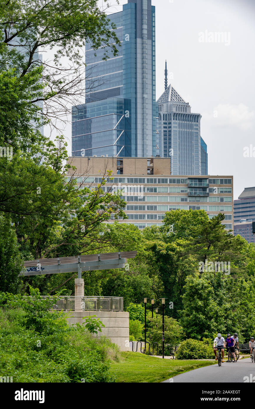 Philadelphia's skyscrapers tower over cyclists on the Schuylkill River Trail at Paine's Park Stock Photo