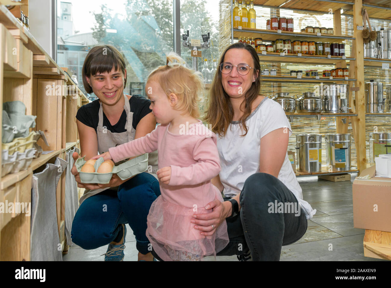 Mother and daughter picking some fresh eggs in zero waste store. Stock Photo