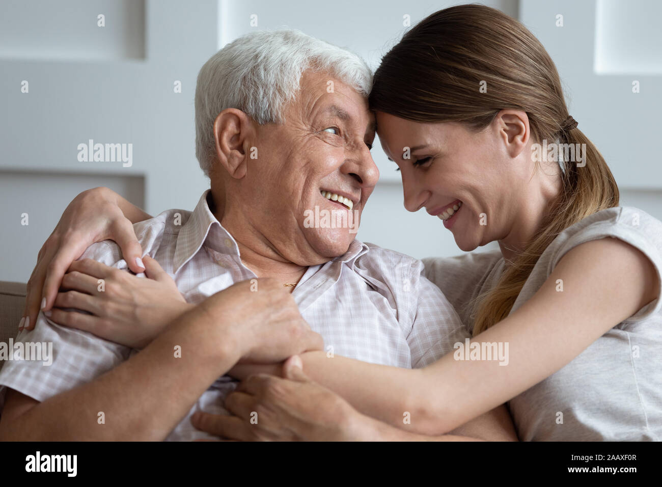 Laughing young 30s woman embracing happy older father. Stock Photo