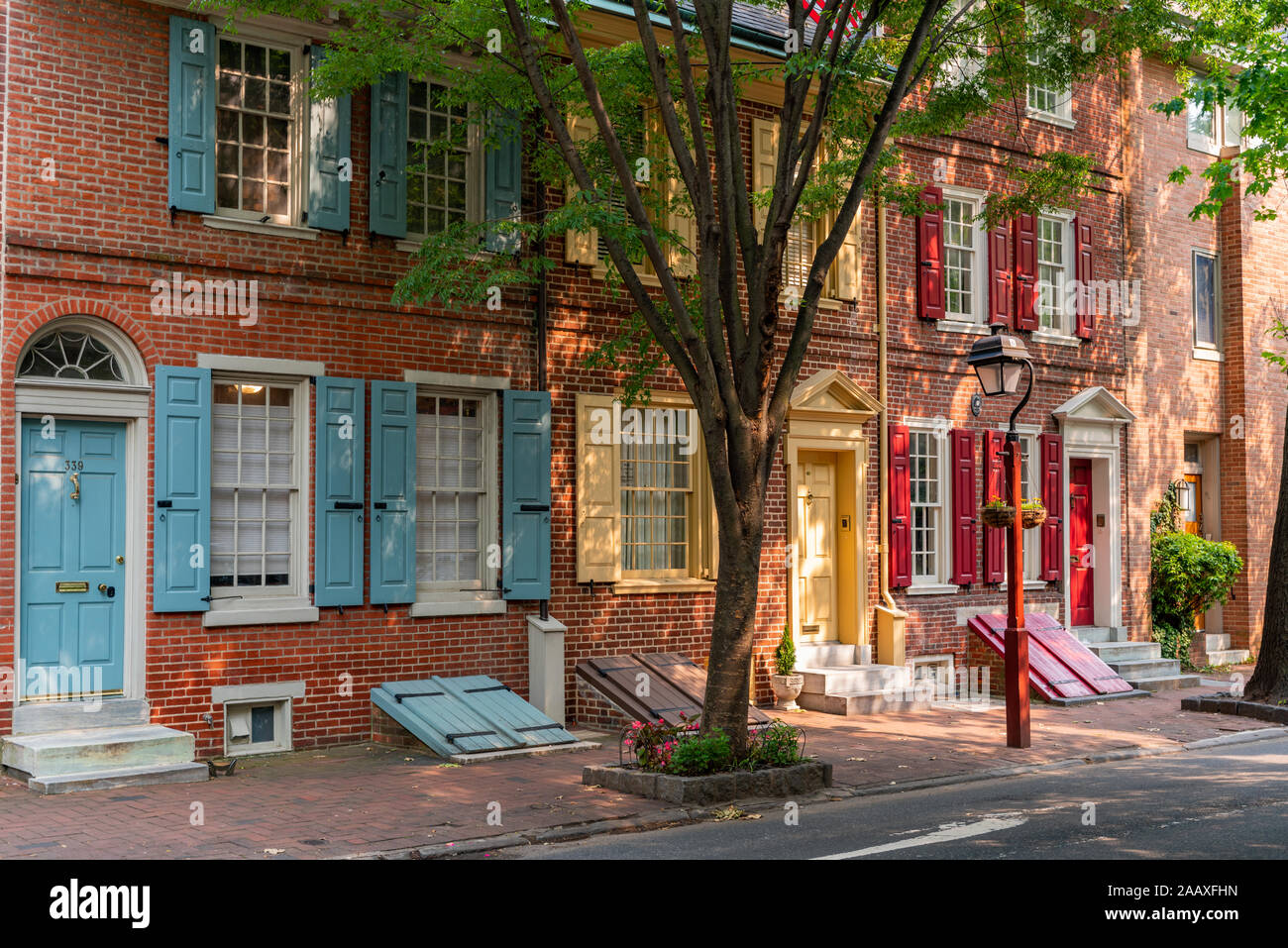 Afternoon sunshine lights up colourful wooden shutters on historic row houses in South 4th Street, Society Hill. Stock Photo