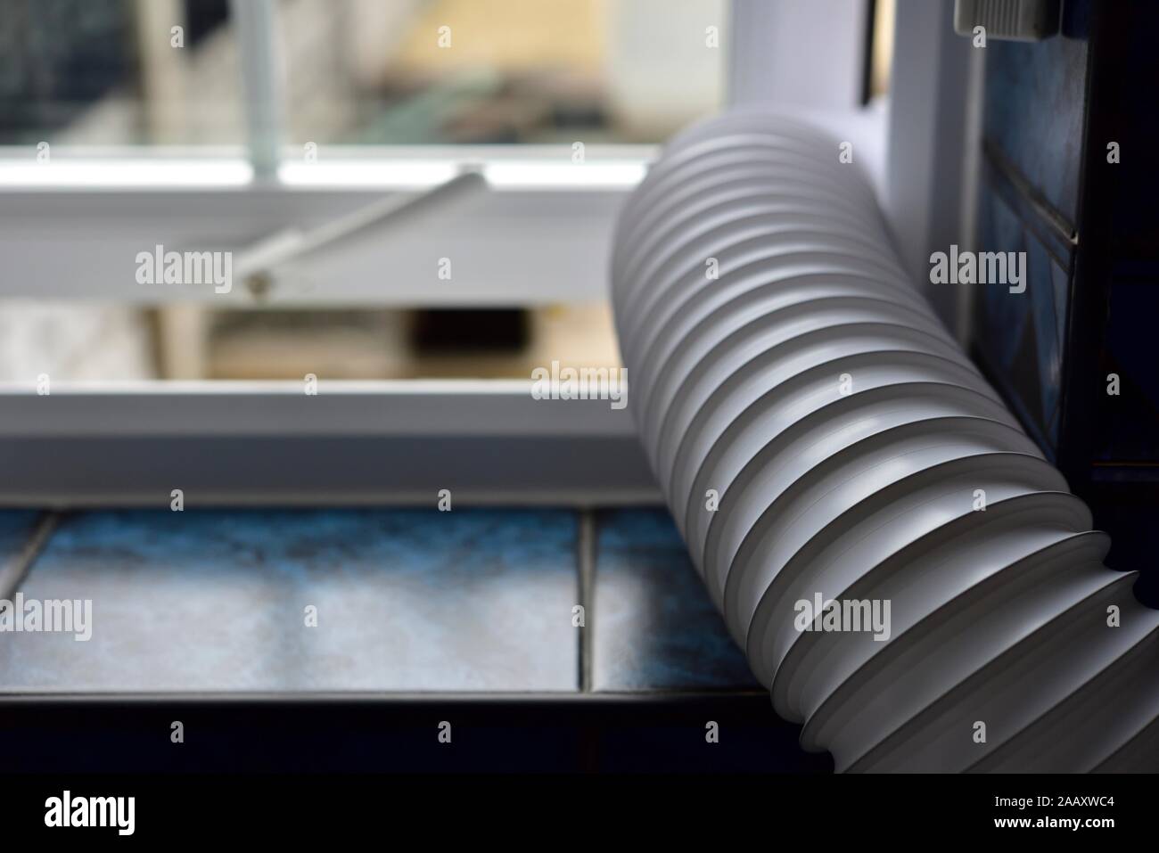 Tumble dryer vent pipe hanging out a window UK Stock Photo