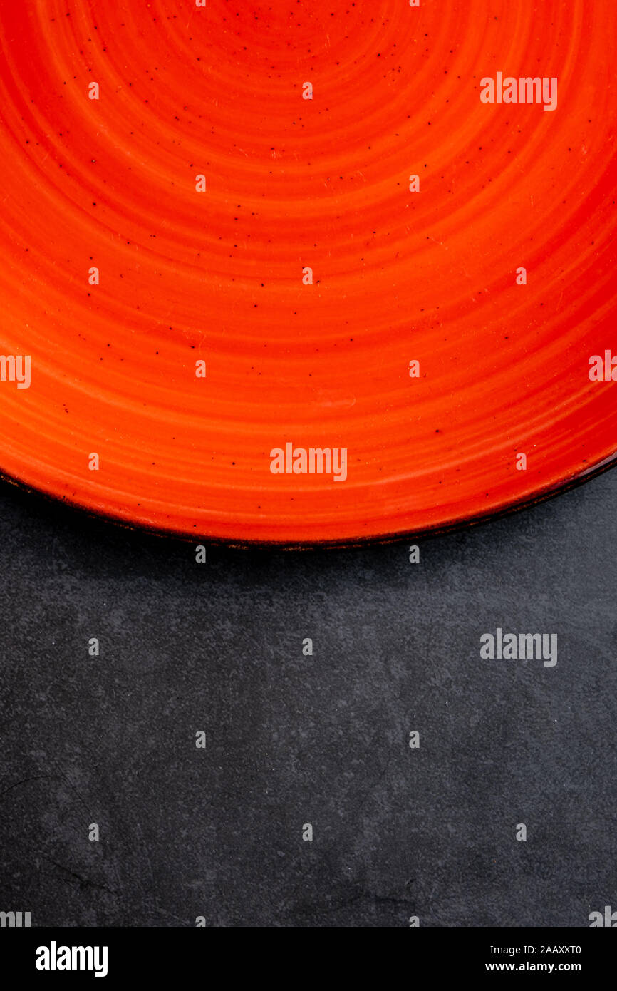empty red plates on black stone background Stock Photo