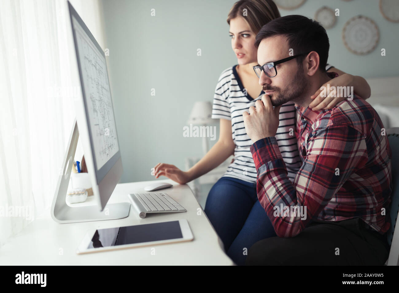 Young couple of designers working on computer Stock Photo