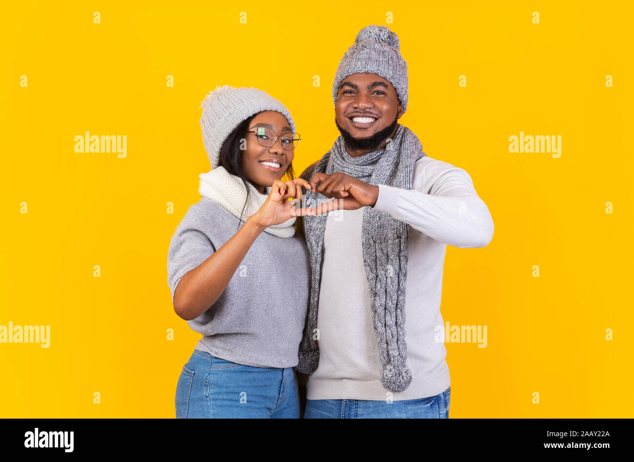 Happy young winter couple showing heart sign with fingers Stock Photo