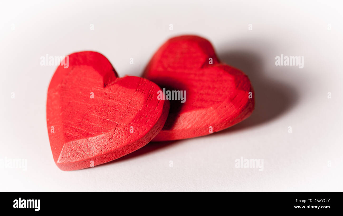 Love and Valentines: love hearts. A pair of red wooden carved hearts isolated on white. Stock Photo