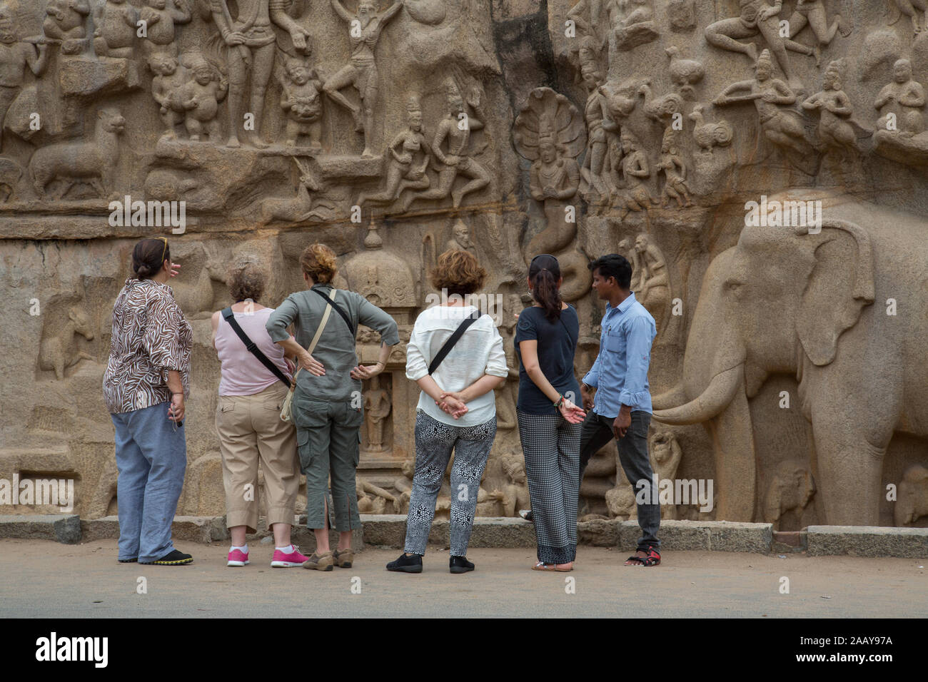 Tourists appreciating the beauty of Arjuna's Penance - The Famous Monolithic Stone Architecture of Mahabalipuram (India) Stock Photo