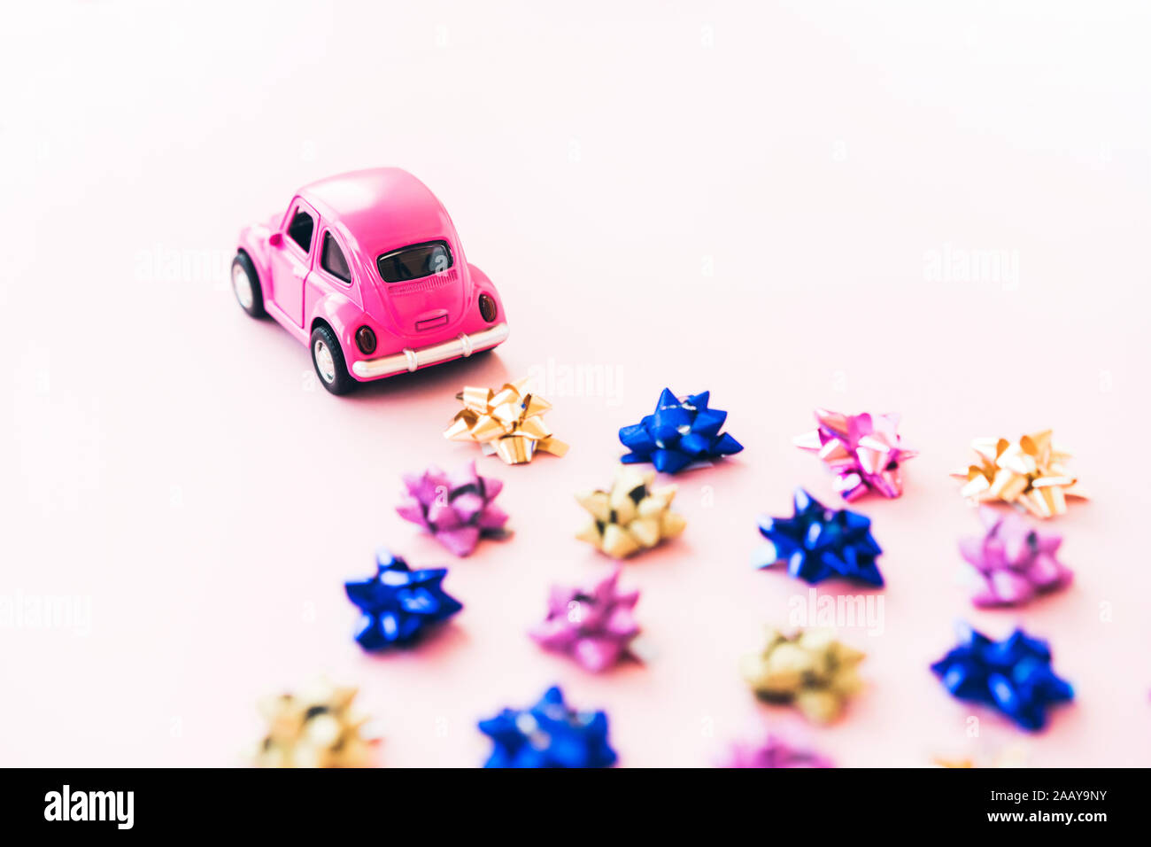 Small toy kids car and multi colored bows for gift wrapping Stock Photo