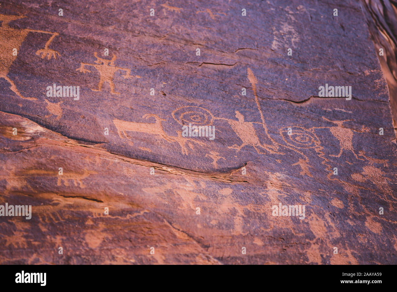 Petroglyph art rock carvings by Native Americans in red desert canyon wall in Utah Stock Photo
