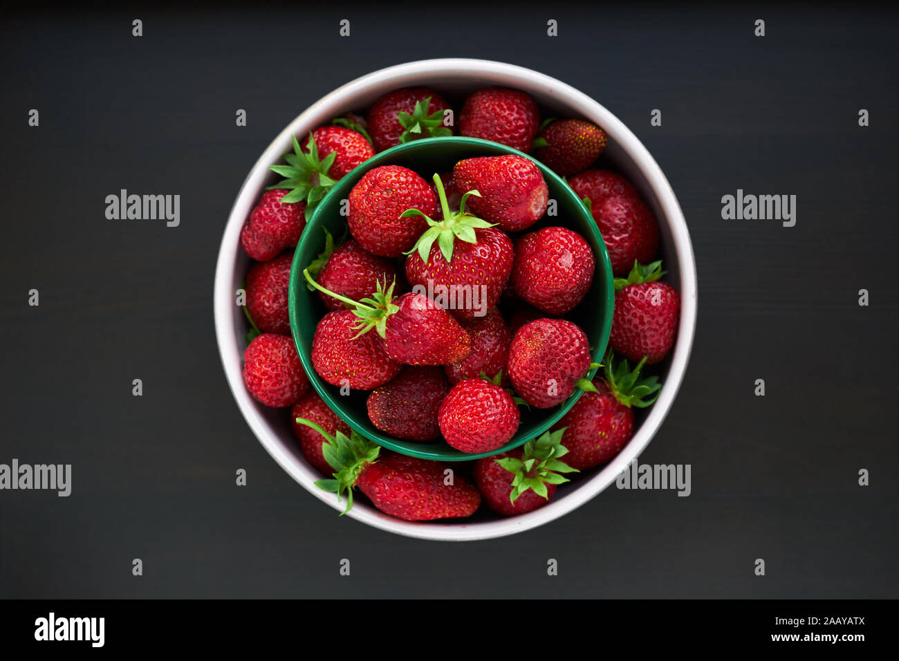 Fresh garden strawberries in round bowls overhead on the table, flat