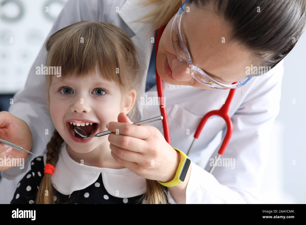 Female dentist look at open mouth litle happy girl Stock Photo Alamy
