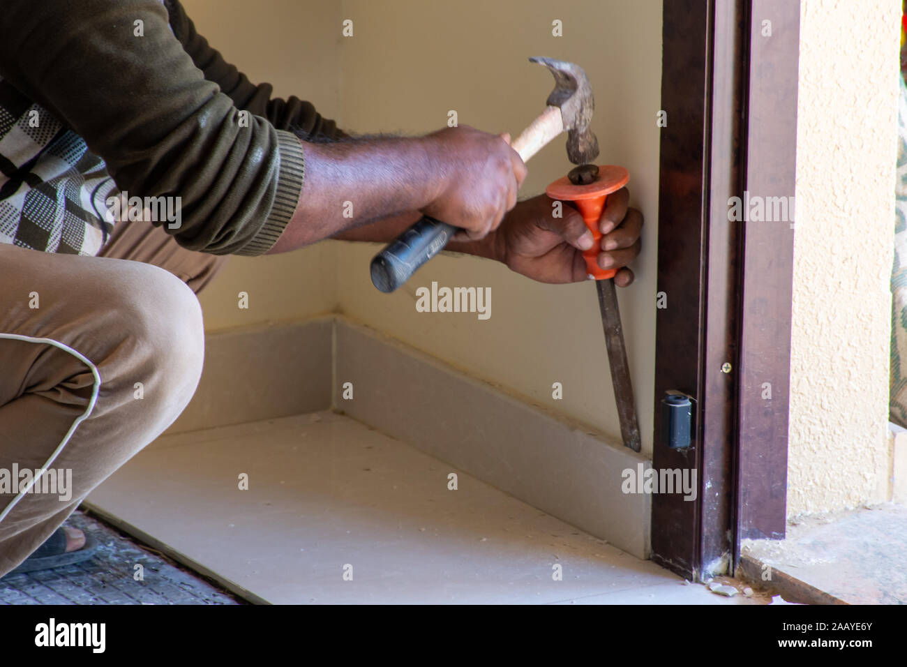 Home renovation close up of chipping ceramic tile baseboard in an