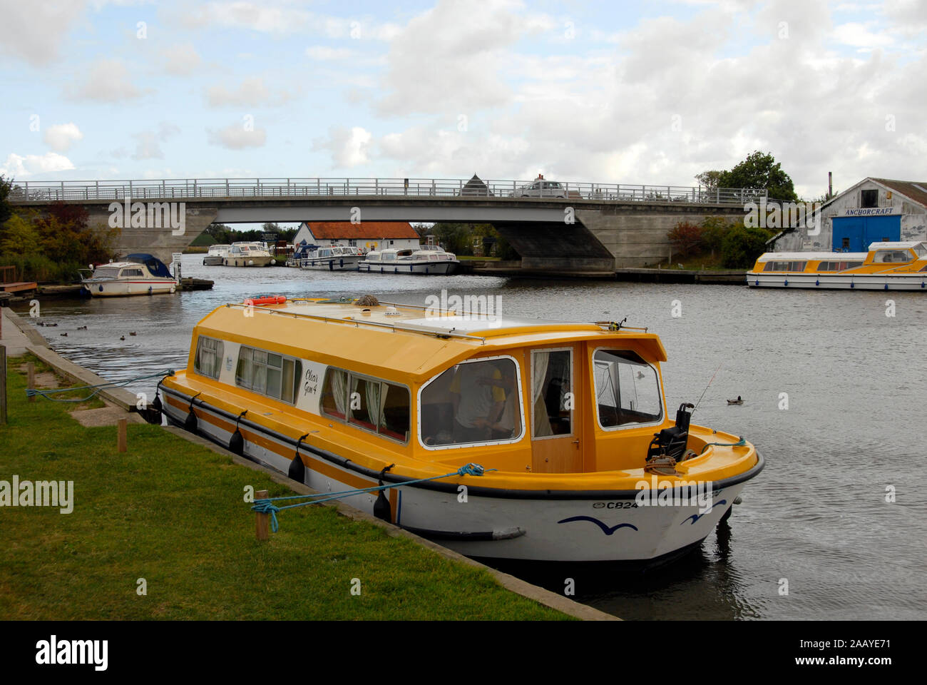 Motor cruiser moored by Acle bridge over the river Bure, Norfolk Broads, England Stock Photo