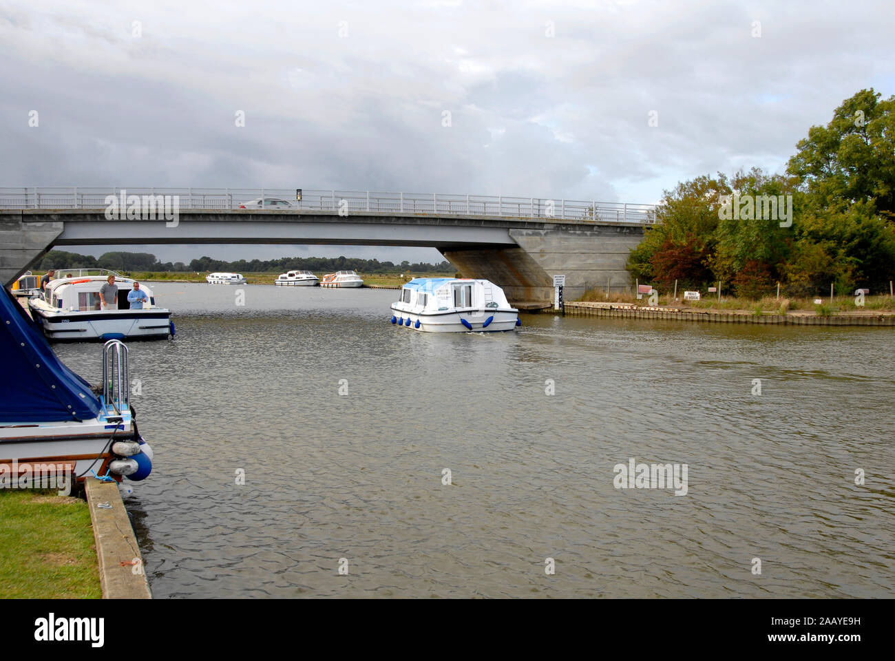 Motor cruiser passing under Acle bridge over the river Bure, Norfolk Broads, England Stock Photo