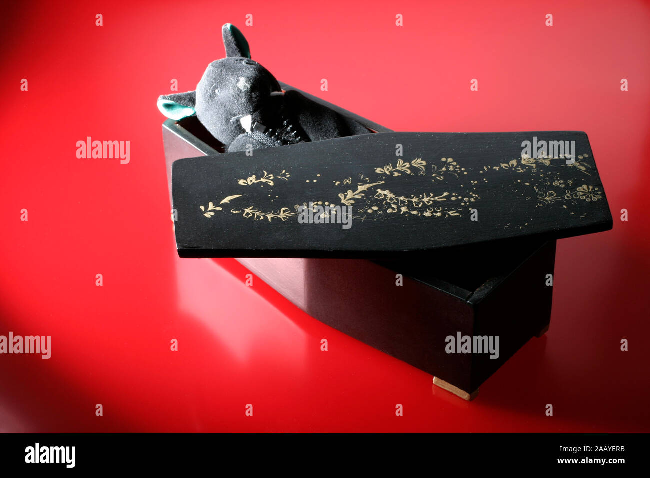 A soft toy vampire bat lying in a coffin Stock Photo