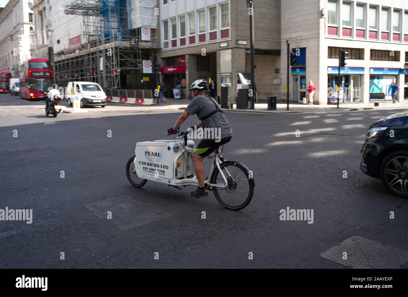 Pearl couriers cyclist out on delivers rides across a junction in London England. Stock Photo