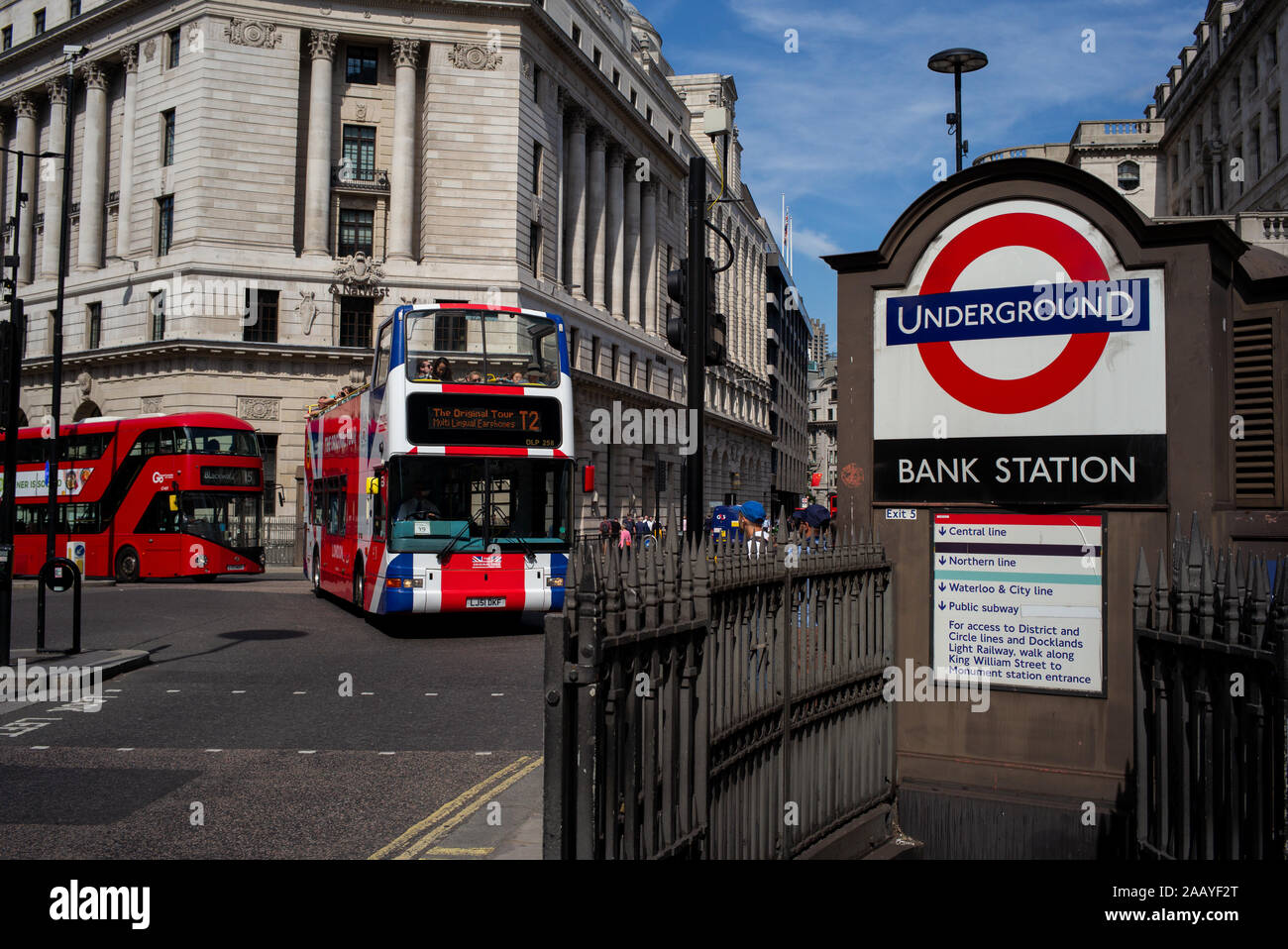 Bank Station street entrance with sign and London tour buses passing. Stock Photo