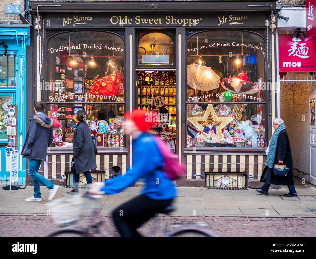Cambridge Shops - A cycist rides past the vintage styled Mr Simms Olde Sweet Shoppe on Kings Parade in central Cambridge Stock Photo