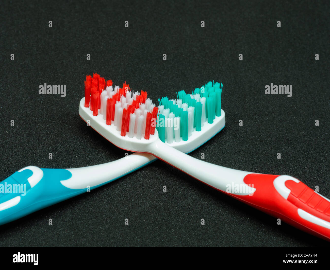 two-tone toothbrushes on dark background Stock Photo