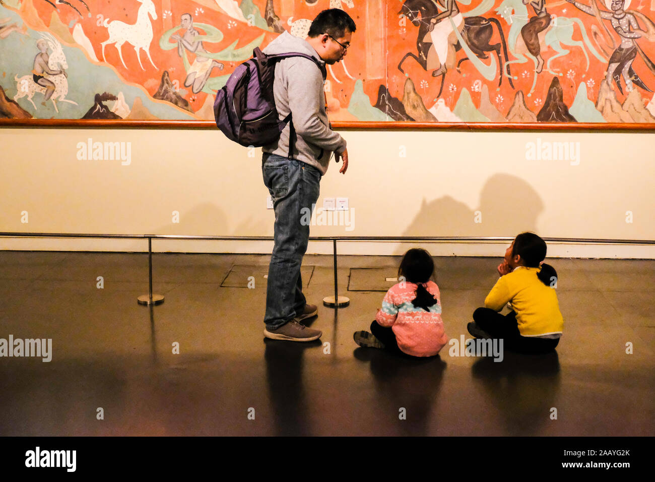 A father explains buddhist apsara painting in China National Museum in Beijing, China Stock Photo