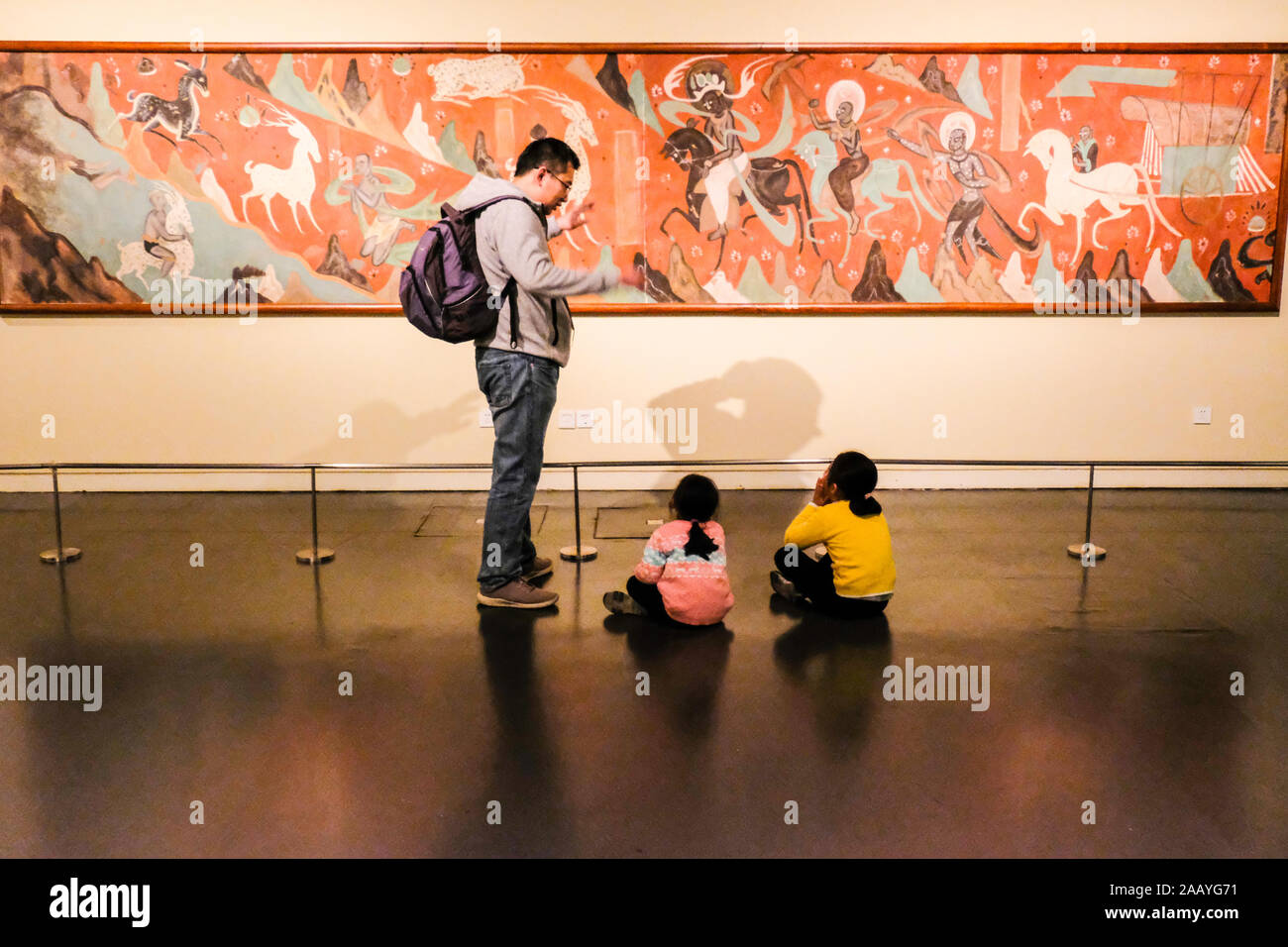 A father explains buddhist apsara painting in China National Museum in Beijing, China Stock Photo