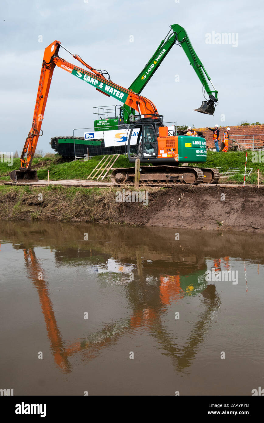 Dredging begins on the local river to prevent further flooding at Moreland in Somerset. Residents Bryony Sadler and her three year old Elsa are hoping that the dredging of the the river will prevent future flooding. March 2014 Stock Photo