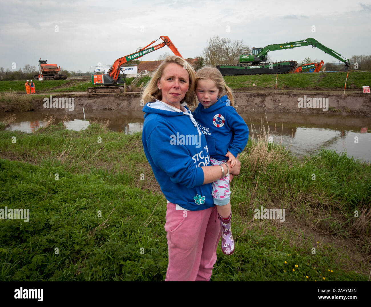 Dredging begins on the local river to prevent further flooding at Moreland in Somerset. Victims of the recent flooding Bryony Sadler and her three year old Elsa are hoping that the dredging of the the river will prevent future flooding. March 2014 Stock Photo